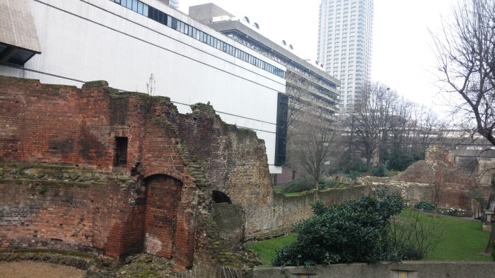 Photo of derelict ancient wall against new white buildings