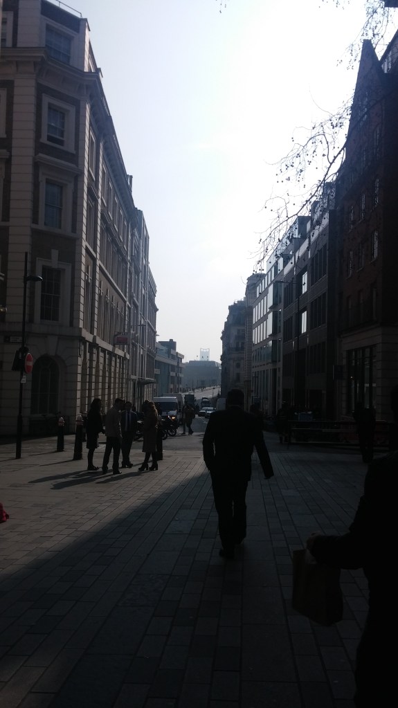 Photo looking between Georgian buildings in the sun with people between them